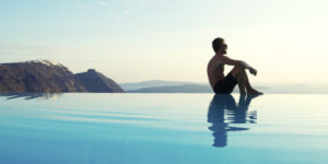 Man Sits Reflecting on Edge of Infinity Pool
